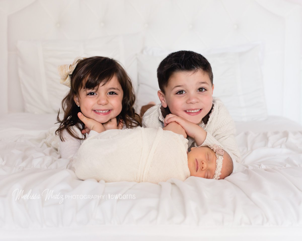 siblings photos with newborn baby sister during newborn photo session 