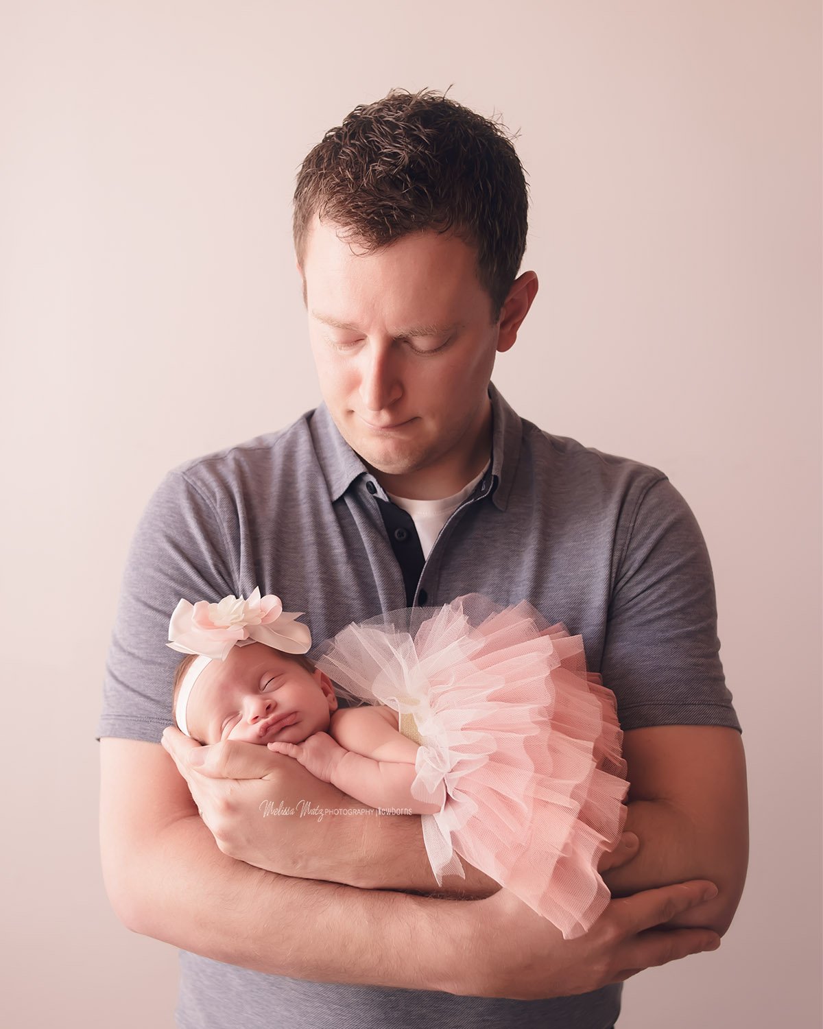 newborn-baby-girl-in-daddys-arms-pink-tutu-macomb-county-newborn-photographer