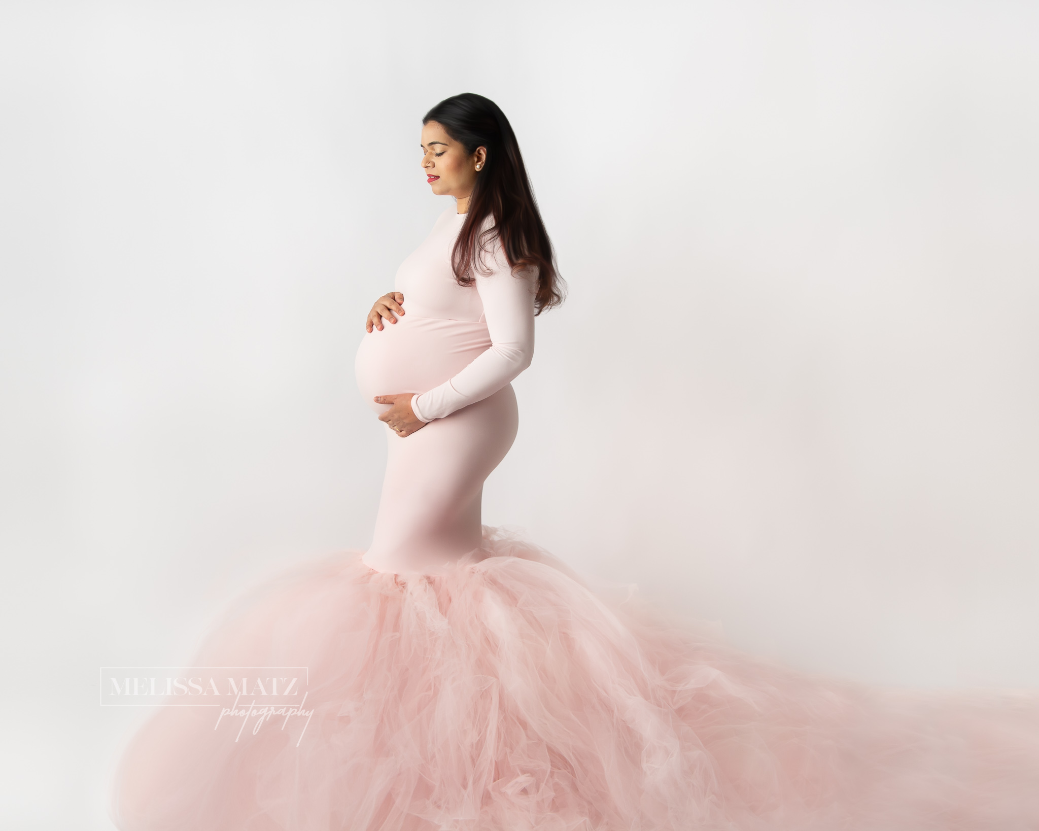 maternity session photo of mom to be in a pink tulle gown