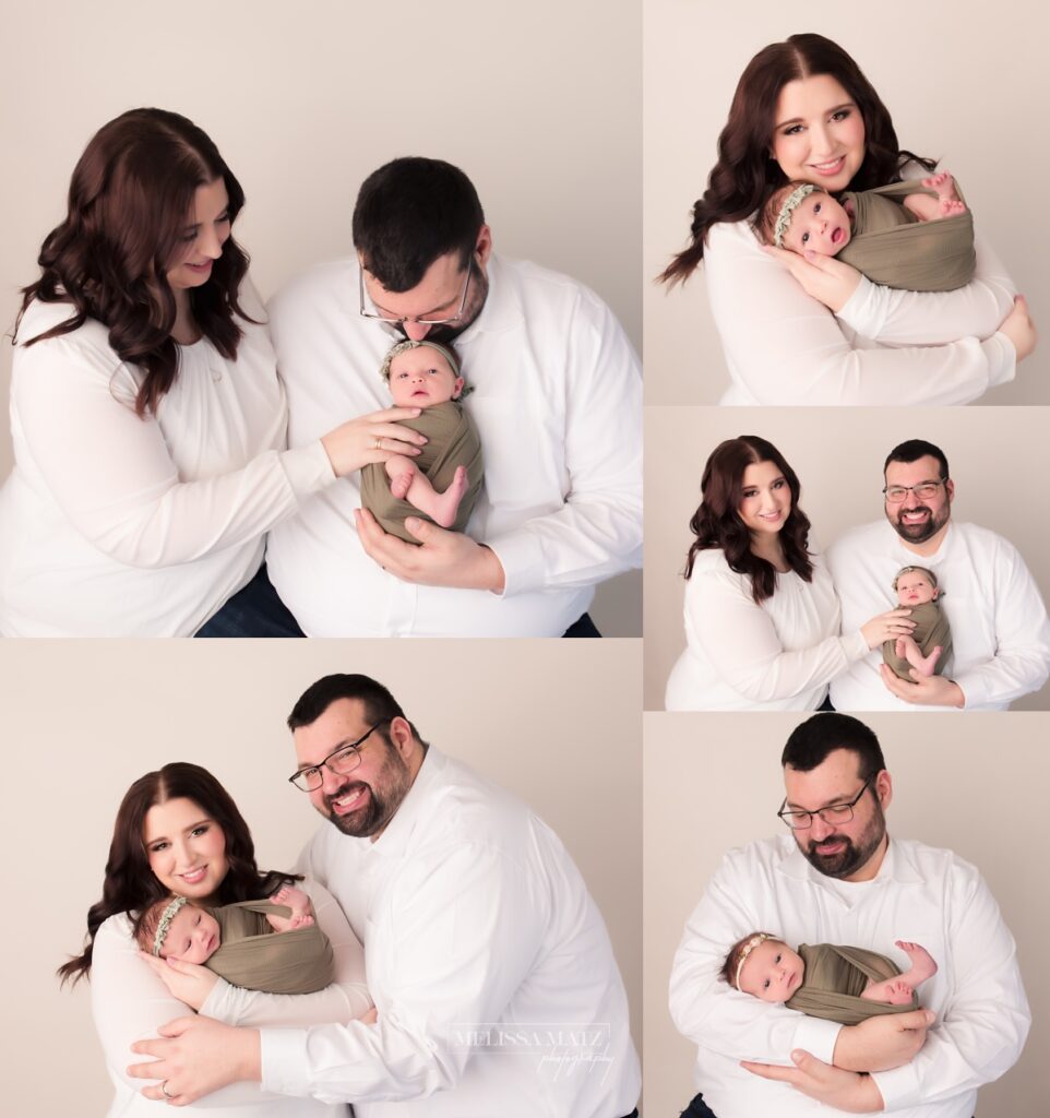 newborn parents holding their swaddled newborn baby girl at their newborn photography session