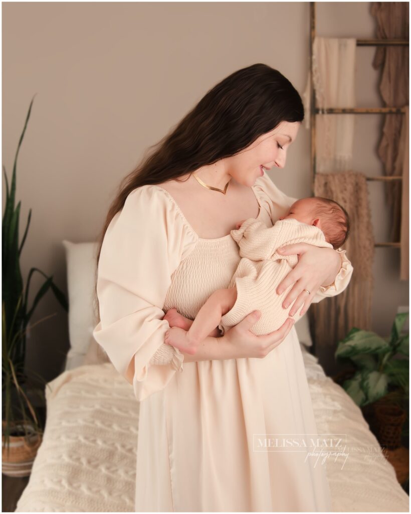 utica mi newborn photographer mom holding new baby boy close to her heart