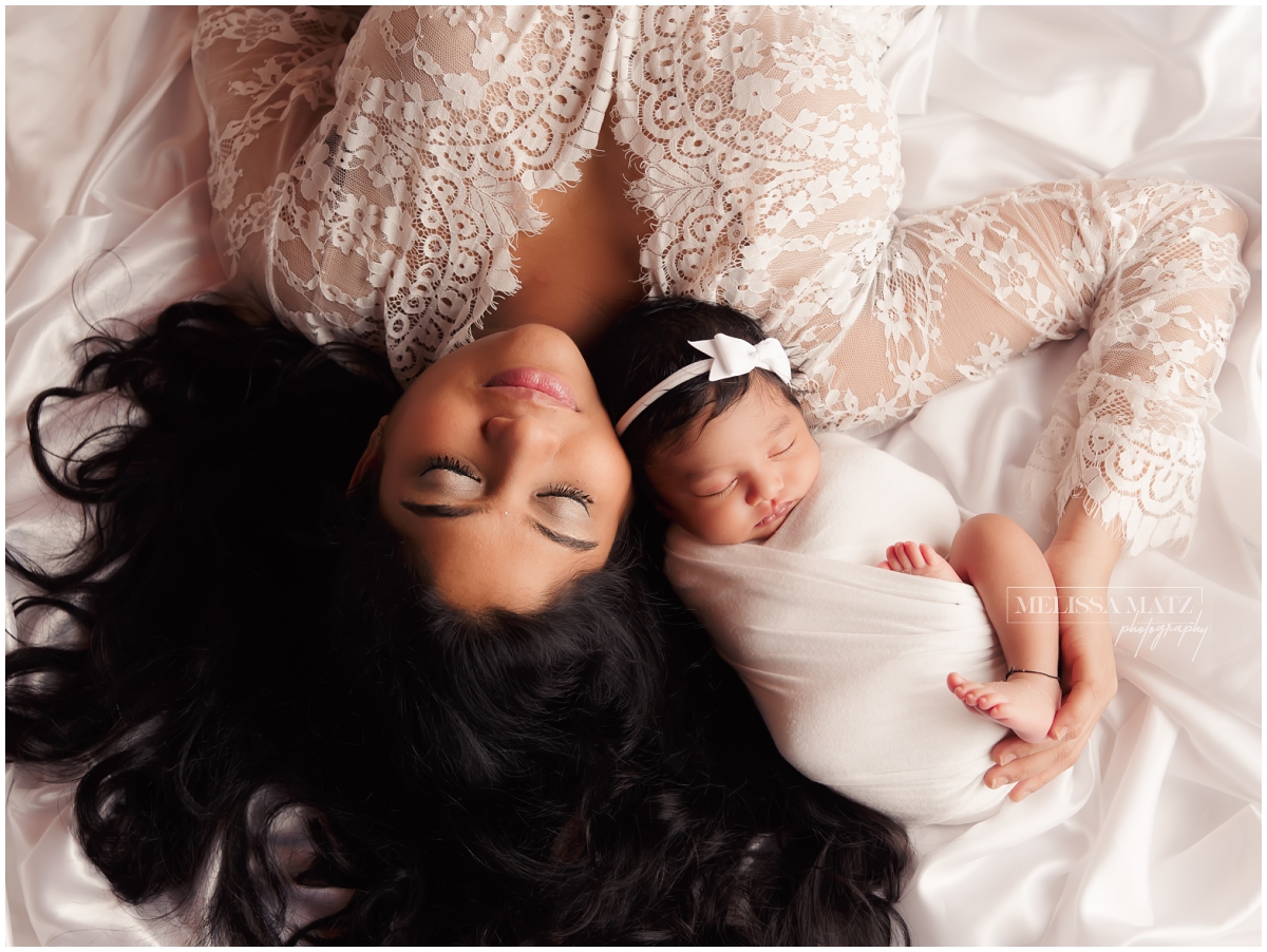 mom holding swaddle wrapped newborn during their newborn session in Shelby Township MI