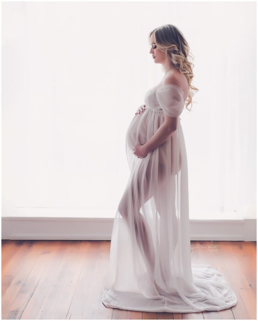 Elegant maternity boudoir portrait of a pregnant woman in soft natural light by Shelby Township MI photographer