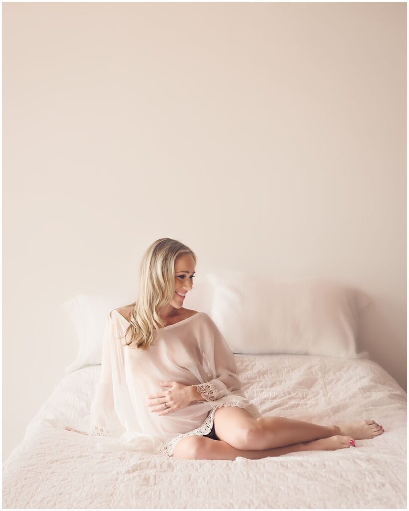 expecting mom to be lying on bed for styled boudoir shoot in macomb county mi photography studio