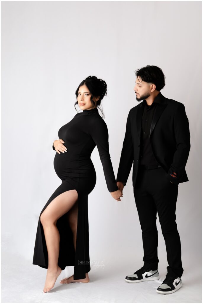 parents to be during their maternity portrait session with dramatic studio lighting
