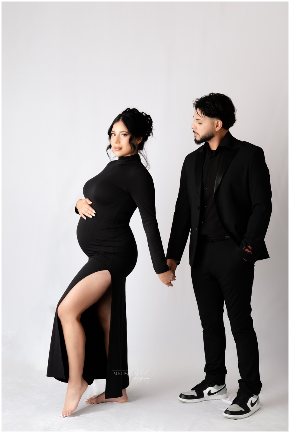 parents to be during their maternity portrait session with dramatic studio lighting