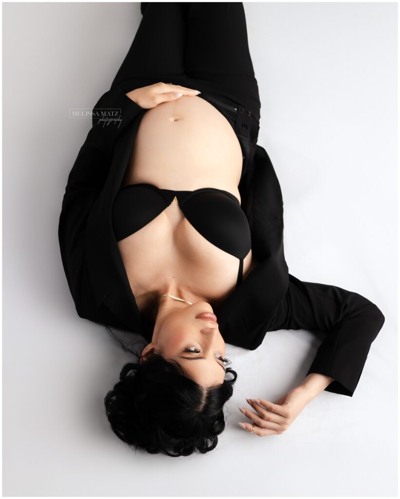 maternity portrait with dramatic studio lighting mom to be laying down