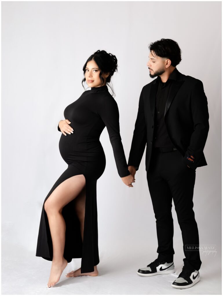 elegant maternity photo studio session mom to be wearing black dress with slit during their session in metro detroit studio