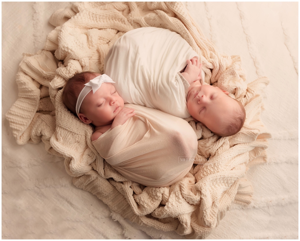 Twin newborns swaddled side by side together during Metro Detroit photography session