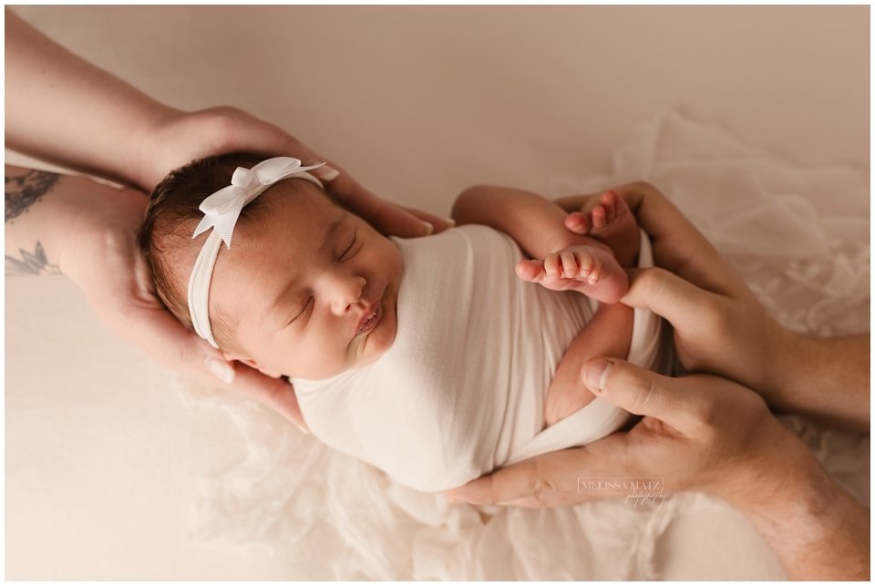 baby cradled in parent hands newborn photography metro detroit