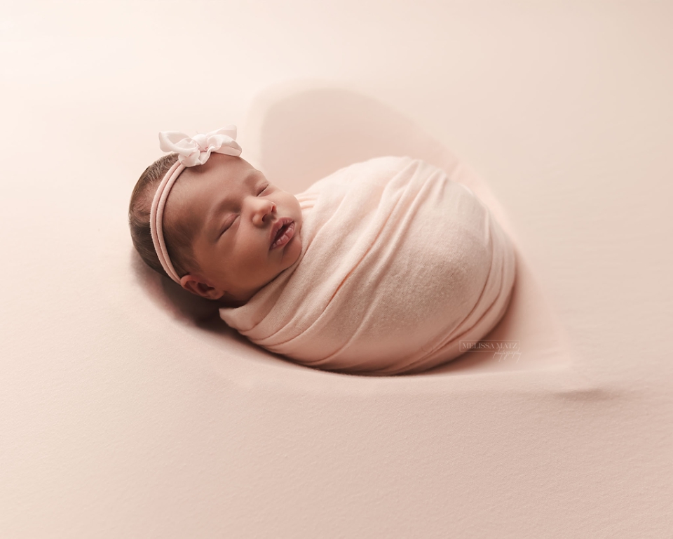 newborn baby swaddle wrapped in a heart bowl at the newborn studio session