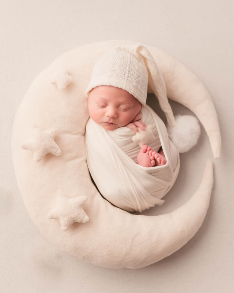 newborn swaddle wrapped holding a star on a moon