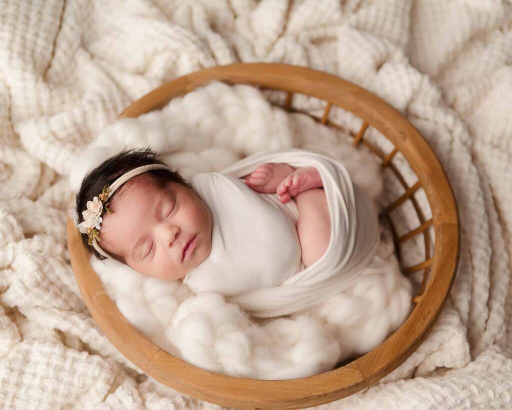 tiny newborn swaddle wrapped in a round basket