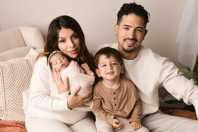 Family in soft coordinated outfits during a newborn session at Melissa Matz Photography studio