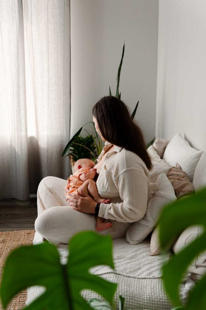 quiet moment between mom and newborn baby during their nursing session in shelby township studio