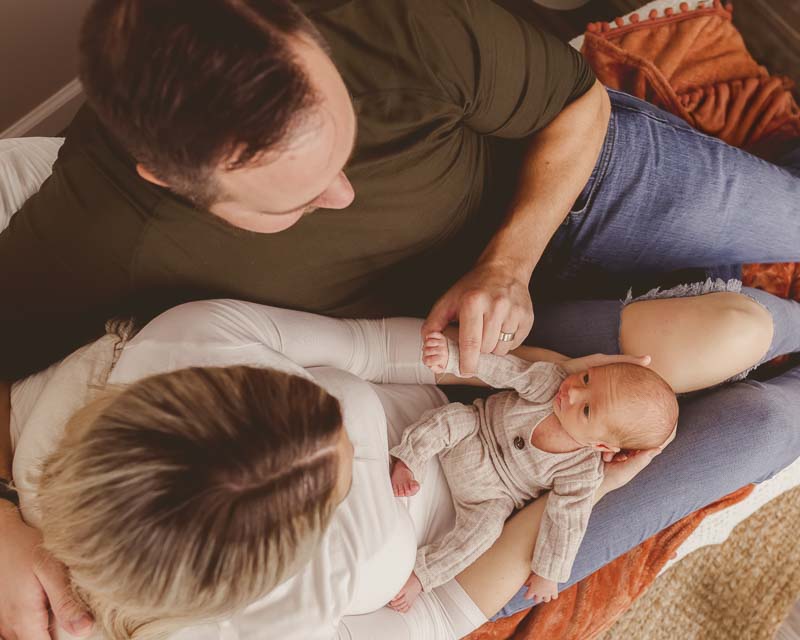 gazing softly down at newborn during an intimate studio lifestyle session