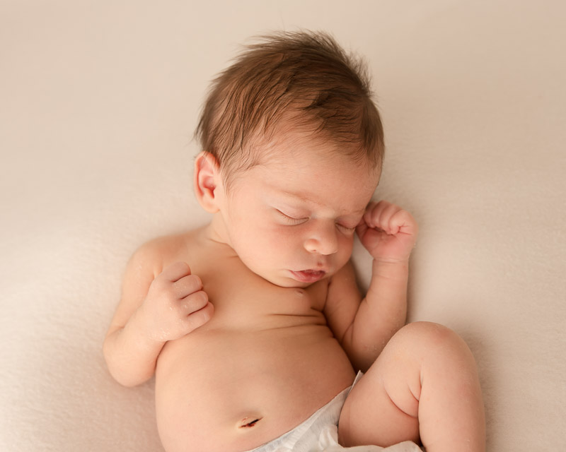 sleeping 2 week old newborn in relaxed pose during newborn photo session