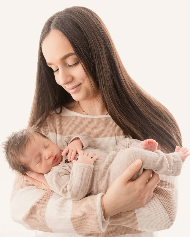 Mother holding her 2-week-old newborn during Metro Detroit newborn session