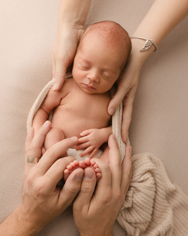 Close-up of newborn baby’s tiny fingers and toes at 2 weeks old
