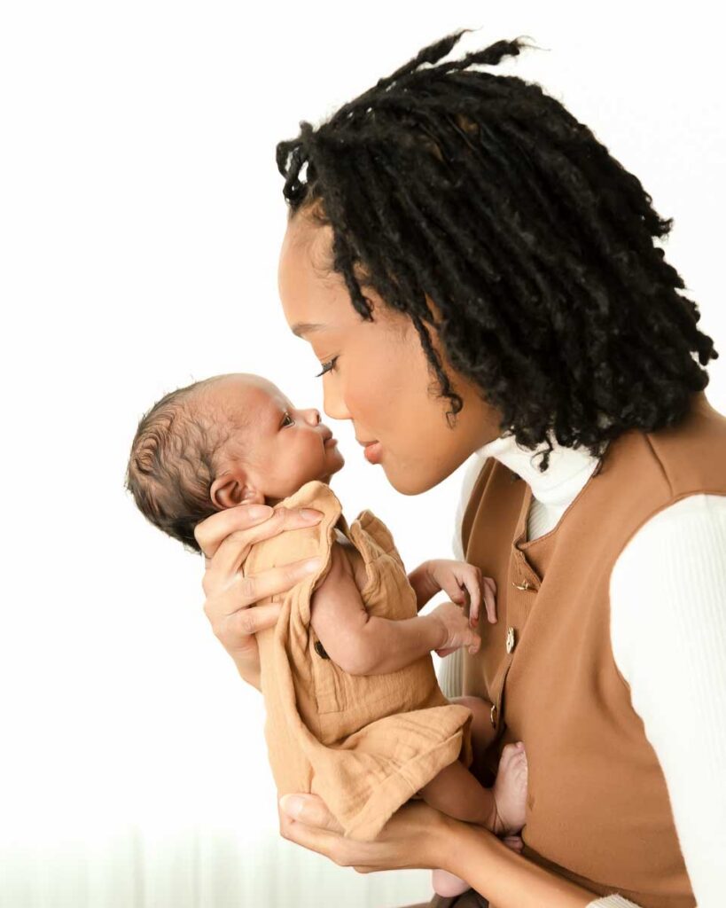 Mother bringing her newborn baby close for a nose to nose moment during a fine art studio newborn session at Melissa Matz Photography