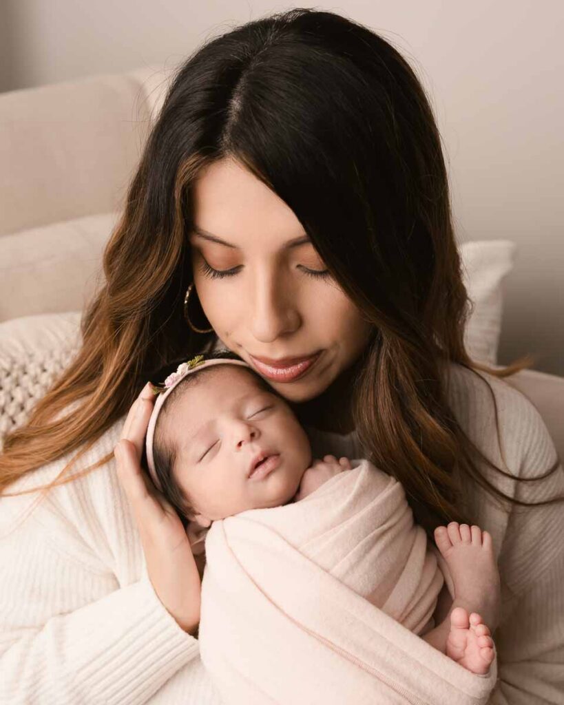 Mother gazing down at her swaddled newborn baby — newborn stage tips for new moms at Melissa Matz Photography in Shelby Township