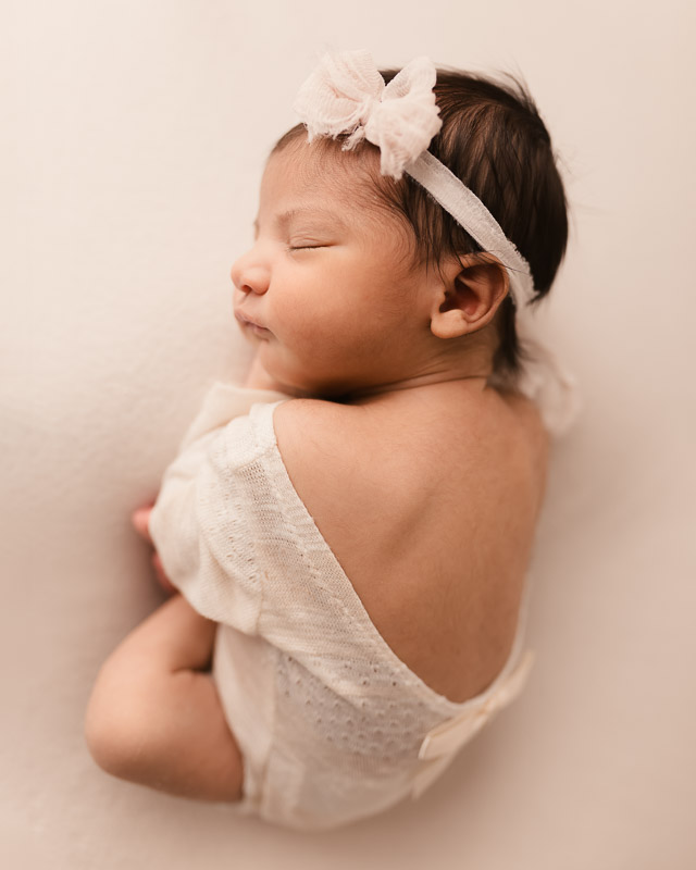 Newborn baby girl in white romper sleeping side profile — Shelby Township newborn session