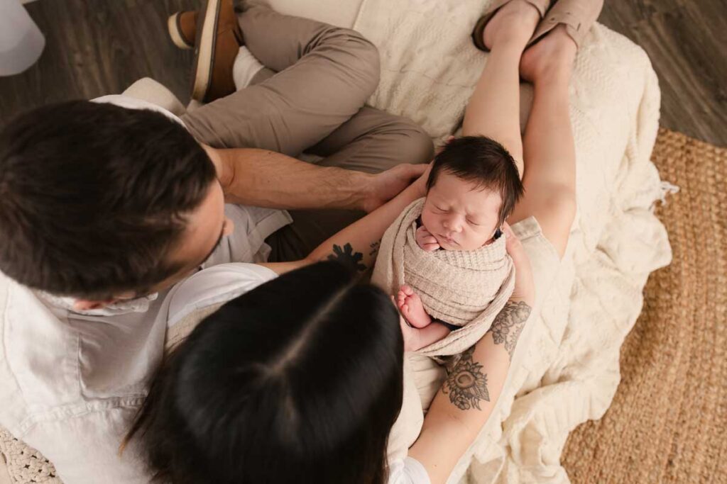 parents holding their newborn baby during a boutique newborn photography session serving Metro Detroit and Macomb County