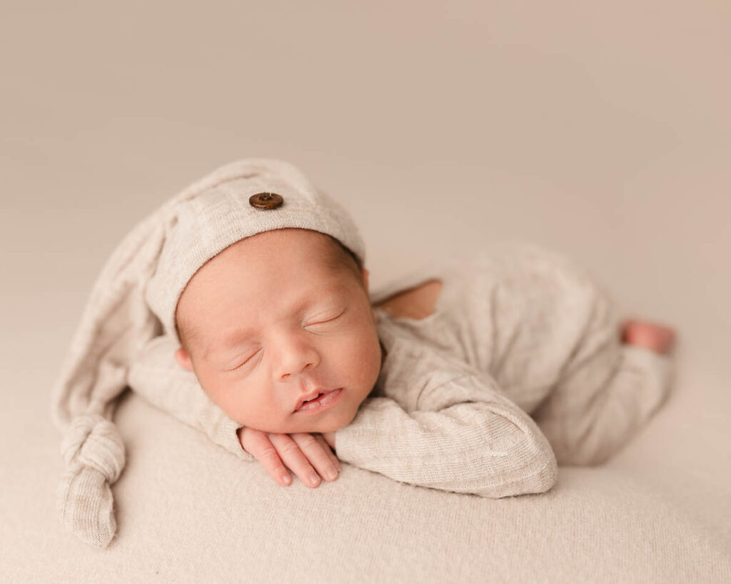 Newborn baby with content expression photographed in macomb county studio
